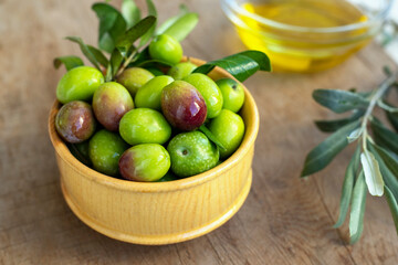 Raw green olives in wooden bowl