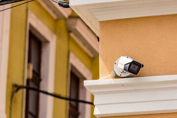 Hidden CCTV installed on the corner of a orange building to ensure security against thieves....