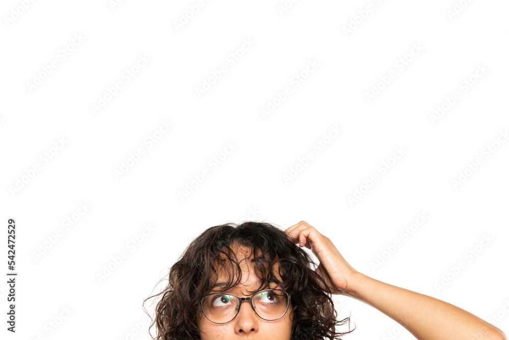 Wall mural closeup portrait headshot cropped face above lips of cute puzzled woman in glasses looking up isolated on white studio wall background with copy space above head. Human face expressions - Wall murals