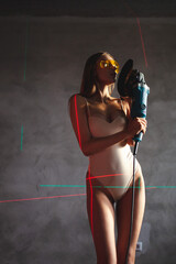 girl in a bodysuit holds a grinder in her hands