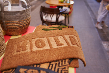 Felpudo que dice Hola en un mercado de pueblo mediterráneo © Hector Milla
