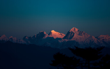 Eerste straal van de ochtendzon op de majestueuze Mt. Everest (de hoogste piek ter wereld) van de Himalaya. Pieken zijn Lhotse, Everest (de gemarkeerde), Makalu en Chomo Lonzo (L naar R). Gezien vanaf Sandakphu.