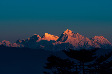 Erster Strahl der Morgensonne auf dem majestätischen Mt. Everest (dem höchsten Gipfel der Welt) des Himalaya. Gipfel sind Lhotse, Everest (der hervorgehobene), Makalu und Chomo Lonzo (L bis R). Von Sandakphu aus gesehen.