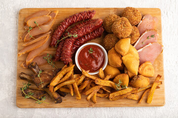 set of snacks: sausages, fried potatoes, meat balls, dumplings, basturma. Top view.