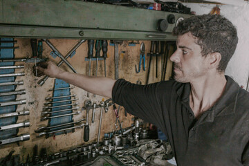 Professional mechanic choosing repair tools in workshop