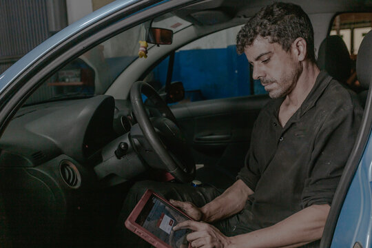Mechanic using laptop in car
