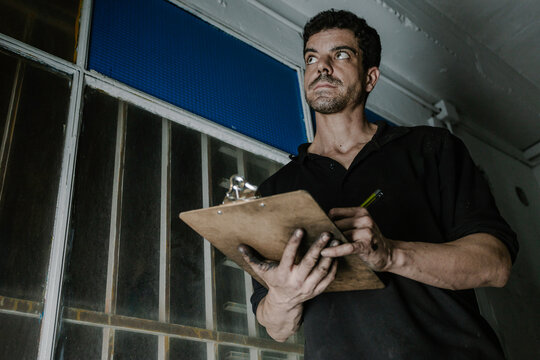 Technician checking paperwork in car service station
