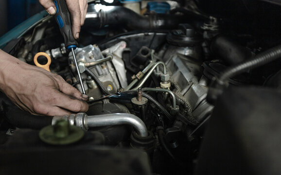Mechanic measuring voltage of car battery