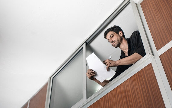 Thoughtful man with paperwork at workplace