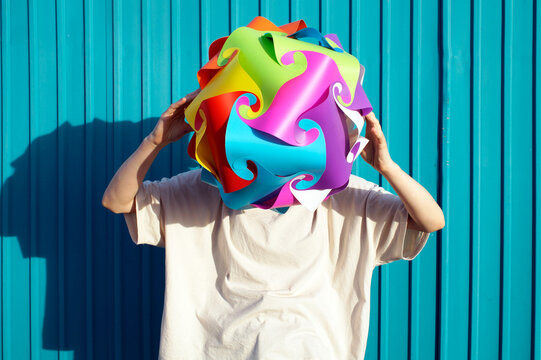 A teenager with a multicolored ball instead of a head. Visualization