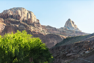 Peak of white rock formations landscape view from road trip in summer in Capitol Reef National Monument in Utah in sunrise with sunlight rays