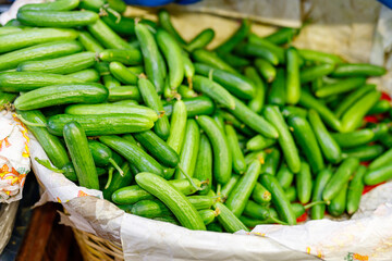 The cucumbers in a supermarket. Fresh cucumber from farm field at market place. A lot of cucumbers. Selling vegetables at the farmer market.