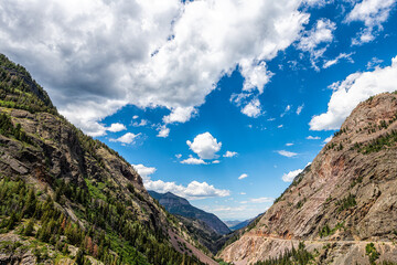 Framing of canyon valley on Million Dollar Highway in Ouray, Colorado with San Juan rocky mountains in summer and blue sky clouds