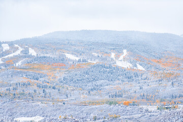 Fototapeta na wymiar Aspen, Colorado in rocky mountains roaring fork valley from high angle view during autumn season changing into snowy winter with yellow foliage