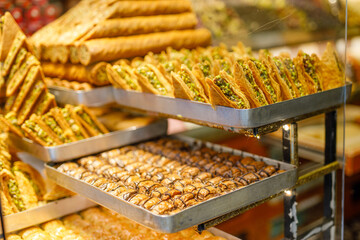 Traditional Turkish dessert Baklava close-up in the local Baklava shop, Turkey. Trays of delicious baklava displayed in showcase of baklavalari cafe
