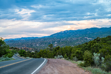 Sangre De Cristo mountains sunset on Bishops Lodge Road street in Santa Fe, New Mexico with pink sunlight by Tesuque residential community