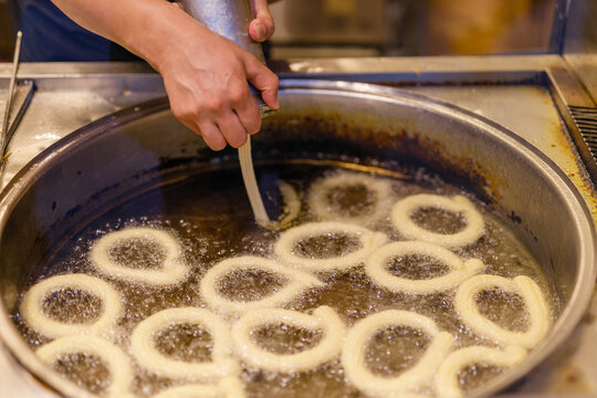 Turkish Dessert Churros Halka Tatli frying in hot oil. Turkish doughnuts or traditional ring sweet - Halka Tatli, kerhane tatlisi.