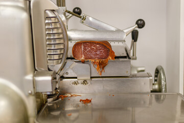 Turkish bacon, pastrami, kayseri pastirma. Turkish pastirma or basturma in the street grocery market with slicer machine