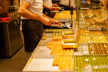 Traditional Turkish dessert Baklava, close-up trays of delicious baklava displayed in showcase of baklavalari shop