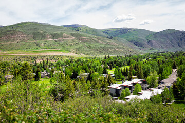 High angle aerial view on mountain town of Avon, Colorado near Beaver Creek ski resort with houses homes by golf club course in summer with green aspen trees - Powered by Adobe