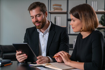 Attentive businesswoman and smiling businessman in formal wear working together