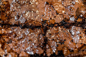 Macro closeup of homemade baked brownie chocolate cake piece sliced bread with crumbles