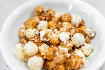 Macro closeup of cheese caramel caramelized popcorn snack sweet treat dessert food in plate bowl isolated against white background