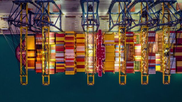 Time lapse of Container ship loading and unloading at night in port.