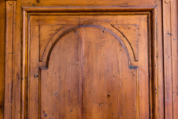 Close up to an yellow wooden door surface of an old construction