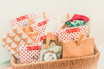Handmade advent calendar with colorful paper bags and stickers in a woven basket