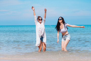 Happy two woman friends enjoying together on the beach. Couple lady are relax on tropical beach feel happy and relax about the summer vacation and having fun.