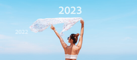 2022 to 2023 to countdown merry christmas and happy new year concept. Woman on a seaside beach...