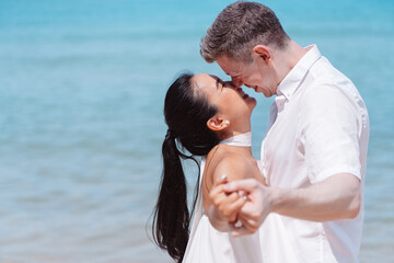 Young couple in love outdoor. Happy man Hugging and dance to his woman romantic at tropical beach. Girlfriend with boyfriend resting travel at sunrise in summer.