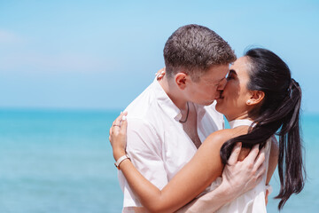 Young couple in love outdoor. Happy man giving piggyback ride to his woman and laughing at tropical...