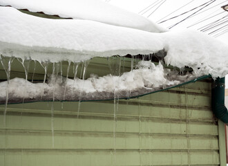 Gutter broken by snow masses sliding from the roof