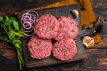 Fresh Raw burger patty, mince beef Meat, uncooked meat cutlets. Wooden background. Top view