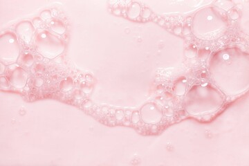 Top view pink soap bar wet with bubbles background