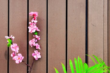 Spring background with pink flowers, cherry blossom decoration on a wooden wall