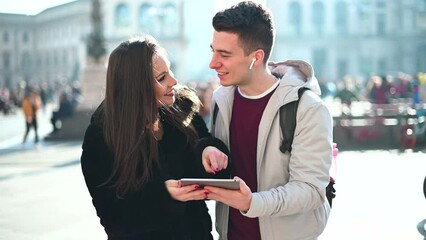 Young couple using a digital tablet outdoor while visiting a city