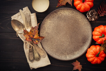 Fall table setting. Craft plate and fall decorations at wooden background. Flat lay image with copy space.
