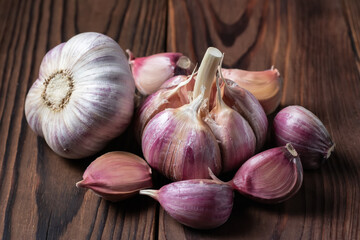 Garlic cloves and bulb on wooden table. Fresh peeled garlics and bulbs.