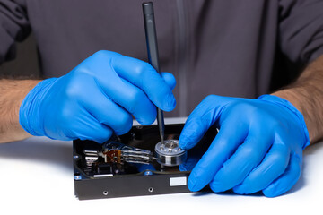 Repair Hard disk. Hands of master in gloves with screwdriver repair the computer hard drive.