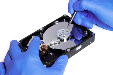 Obraz premium Repair Hard disk. Hands of master in gloves with screwdriver repair the computer hard drive.