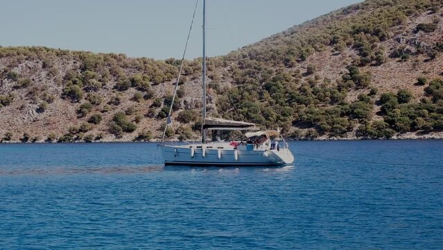Beautiful bay with sailing boat, yacht in turquoise sea and mountains, luxury holidays or sailing regata sports.