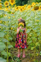 girl with sunflower covers her face in a red dress