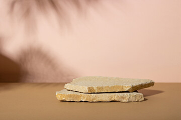 Background with an empty stack of stones on a beige background. Stone podium for cosmetic products....
