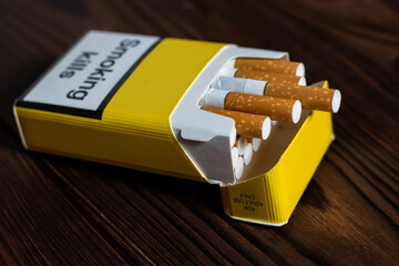 Open pack of cigarettes on wooden background