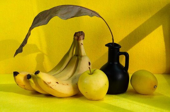 Banana and yellow apple on a yellow background with copy space. Image for design, project, postcard. Ripe fruit on yellow paper. Yellow Photo Concept 
