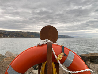 Bouée de sauvetage orange sur le bord d'une jetée. Anneau de sécurité pour des sauvetage en...