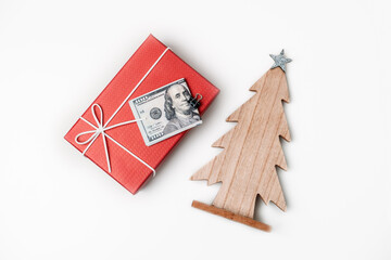How To Spend, Christmas budget and saving concept. Xmas gift box, Stack of dollar bills and wooden Christmas tree on white table